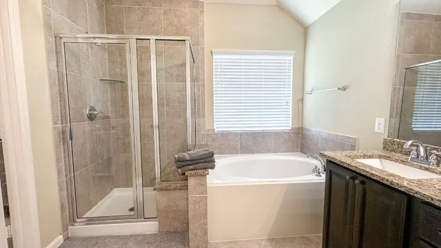a bathroom with a granite countertop sink a mirror and a bathtub