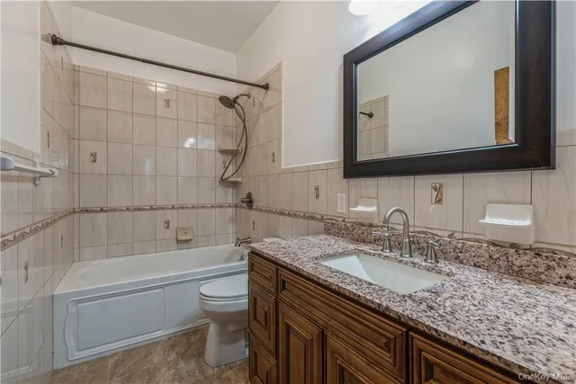 a bathroom with a granite countertop sink a mirror and a bathtub