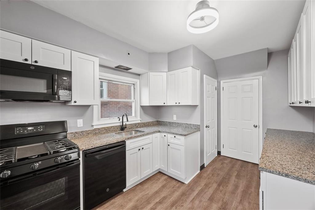 76 Montclair Avenue Pittsburgh, PA 15229 - Photo 11 of 34 a kitchen with stainless steel appliances granite countertop a sink dishwasher a stove and a microwave oven with cabinets
