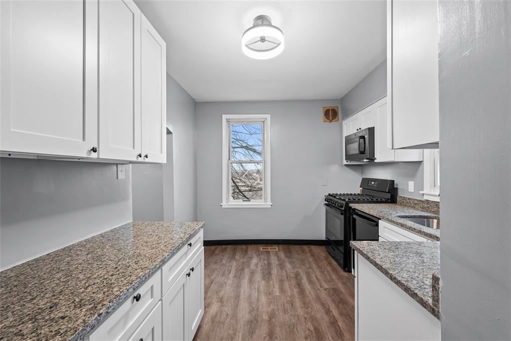 76 Montclair Avenue Pittsburgh, PA 15229 - Photo 14 of 34 a kitchen with granite countertop a stove a sink and a microwave