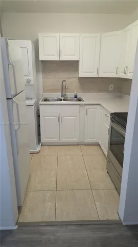 a kitchen with white cabinets and white appliances