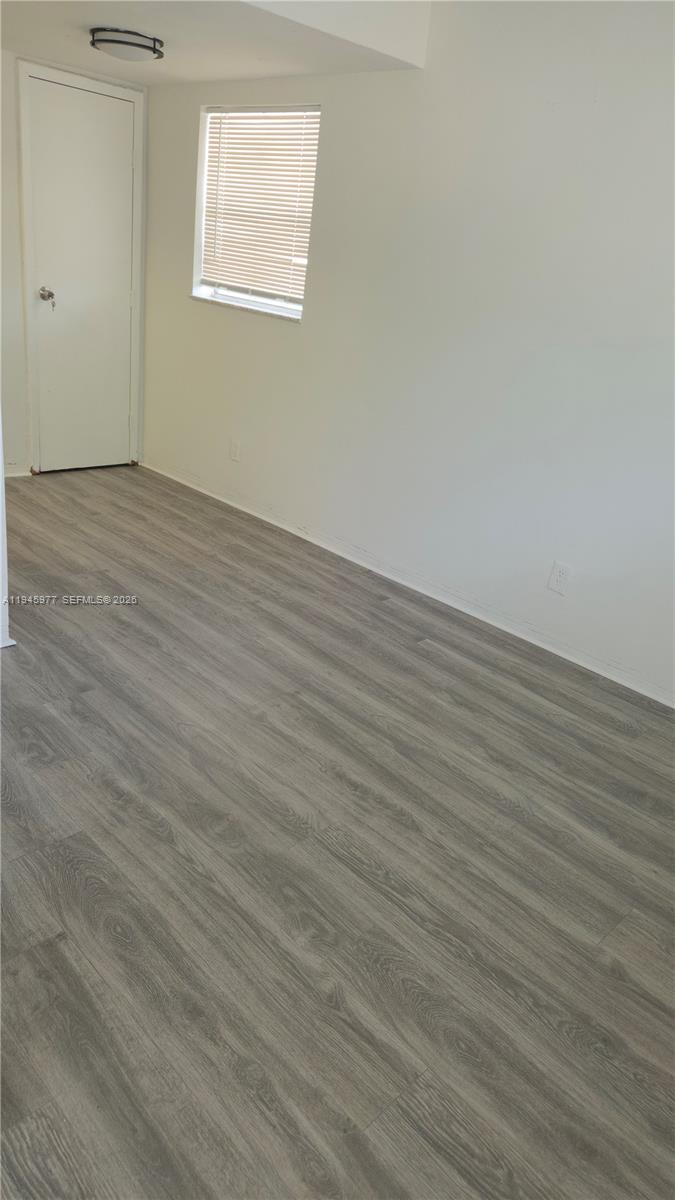 502-504 Phippen Waiters Road, Unit 3 Dania Beach, FL 33004 - Photo 3 of 22 an empty room with wooden floor and windows