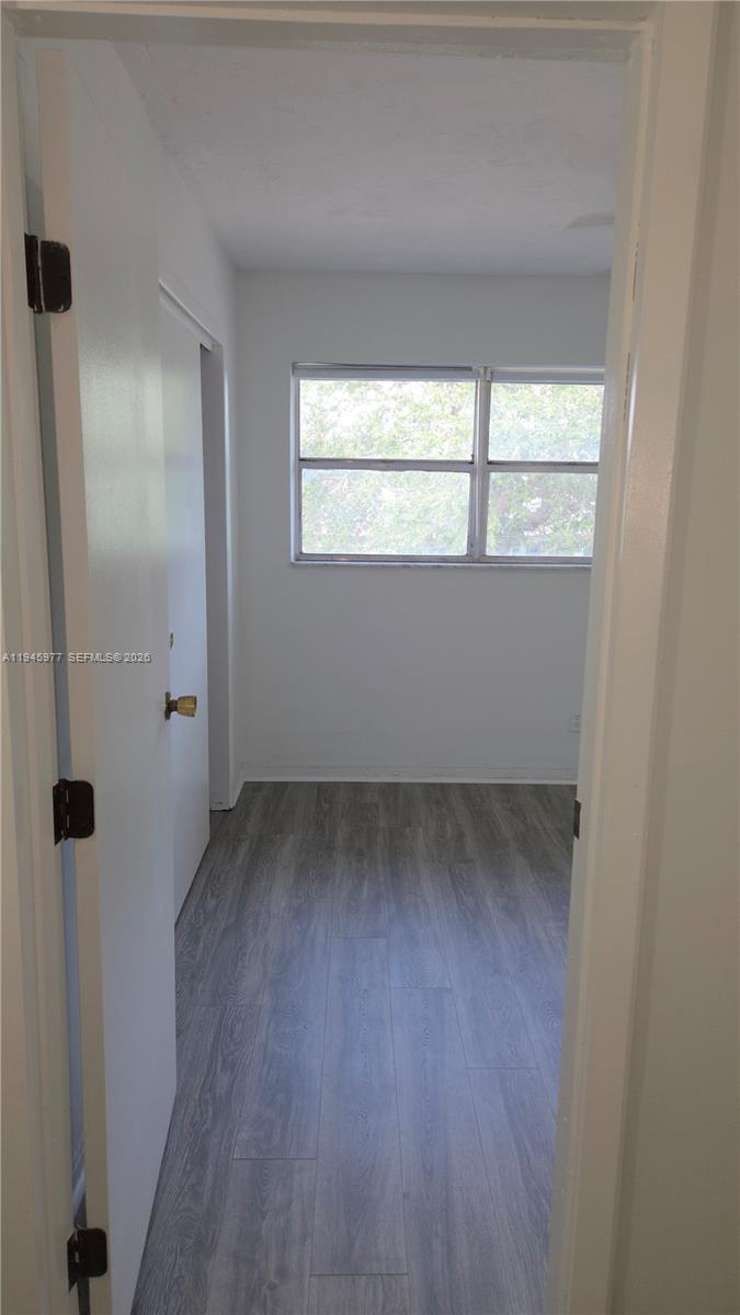 502-504 Phippen Waiters Road, Unit 3 Dania Beach, FL 33004 - Photo 6 of 22 a view of an empty room with wooden floor and a window