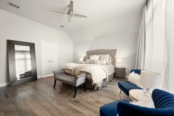 a spacious bedroom with a bed couch and a window