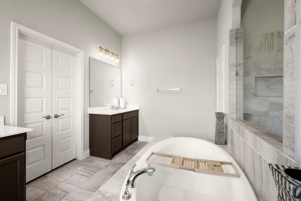 a bathroom with a tub sink and mirror