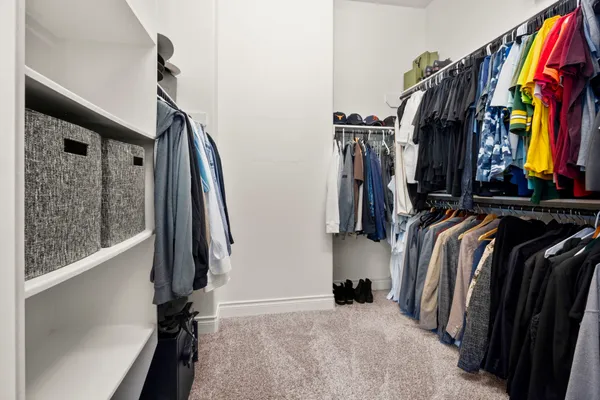 a view of walk in closet with clothes and shoes