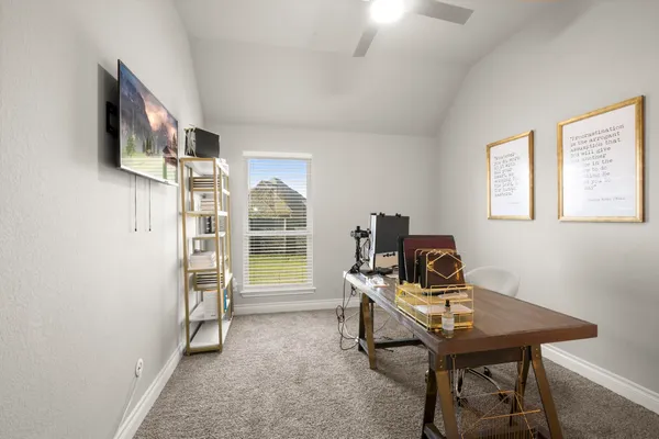 a view of a workspace with furniture and a window