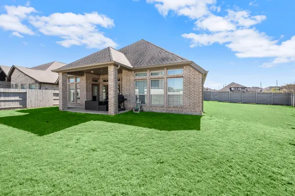 a view of a house with a big yard and large tree