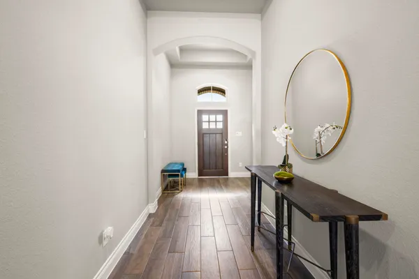a view of a hallway with wooden floor and entryway