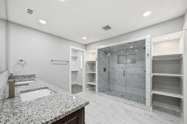 a bathroom with a granite countertop sink and shower
