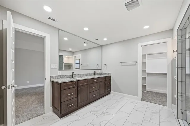a bathroom with a granite countertop sink mirror and