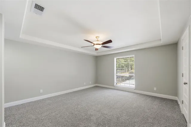 an empty room with windows and ceiling fan