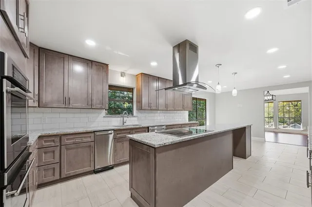 a kitchen with stainless steel appliances granite countertop a sink counter space cabinets and a large window