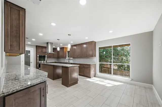 a kitchen with stainless steel appliances granite countertop a sink stove and cabinets