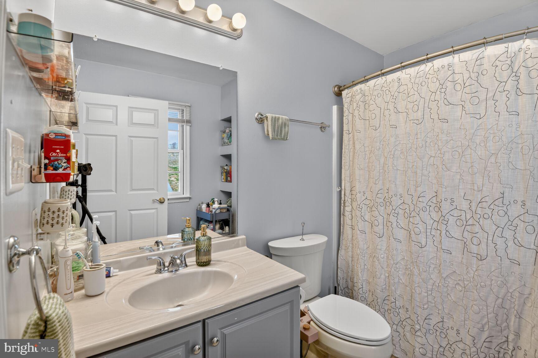 2338 Jim Kohler Road Eldersburg, MD 21784 - Photo 38 of 63 a bathroom with a sink a toilet and shower curtain