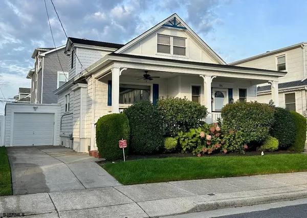a front view of a house with a garden and plants