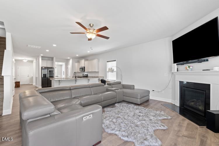 117 Boomer Street Benson, NC 27504 - Photo 15 of 31 a living room with furniture a fireplace and a flat screen tv