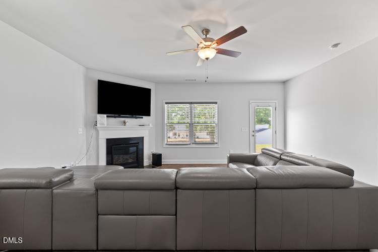 117 Boomer Street Benson, NC 27504 - Photo 16 of 31 a living room with furniture a flat screen tv and a fireplace