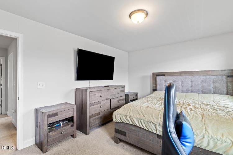 117 Boomer Street Benson, NC 27504 - Photo 27 of 31 a bedroom with a bed and a flat tv screen on wall