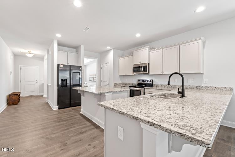 117 Boomer Street Benson, NC 27504 - Photo 10 of 31 a large kitchen with stainless steel appliances granite countertop a lot of counter space and wooden floor