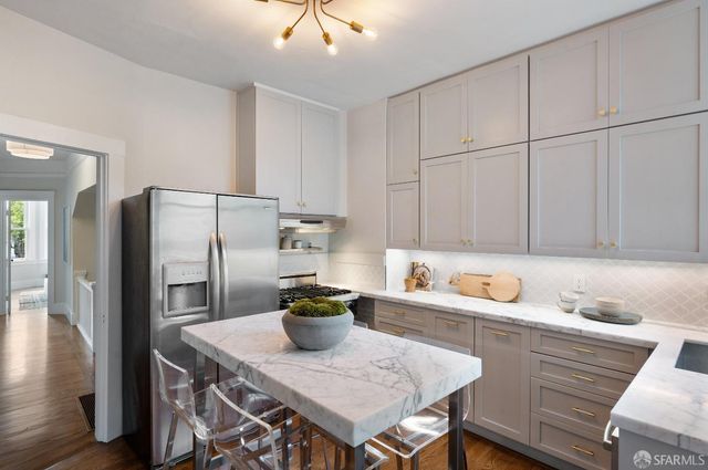a kitchen with stainless steel appliances granite countertop a sink refrigerator and cabinets