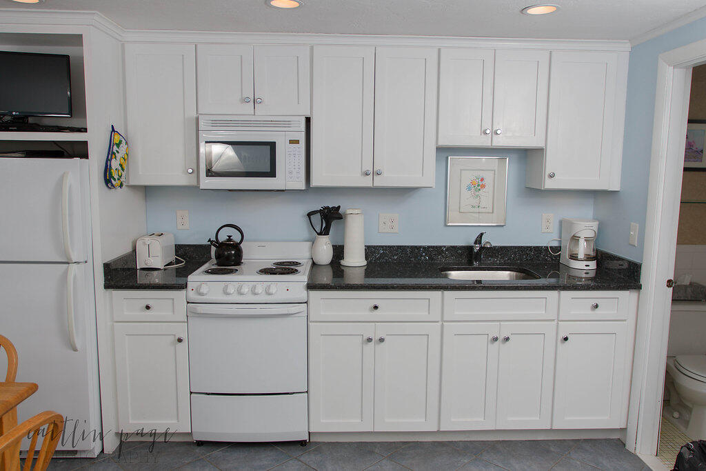 154 Old Wharf Road, Unit 19 Dennis Port, MA 02639 - Photo 3 of 15 a kitchen with white cabinets and white appliances