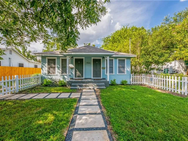 a front view of a house with a garden and yard