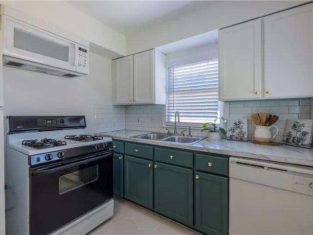 a kitchen with stainless steel appliances a stove a sink and cabinets