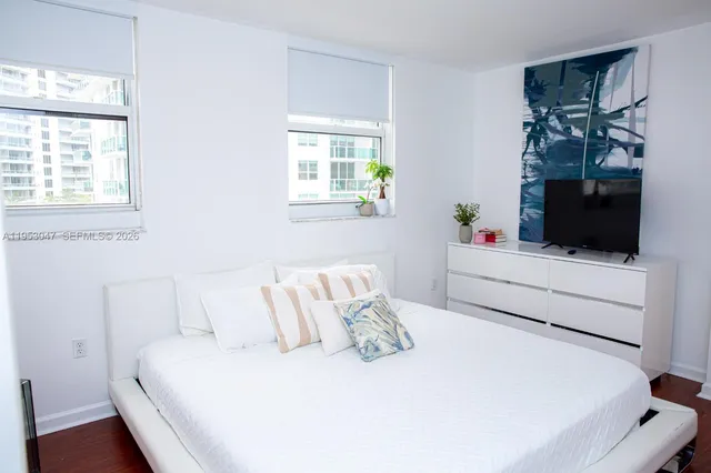 a bedroom with a bed a flat screen tv and a couch