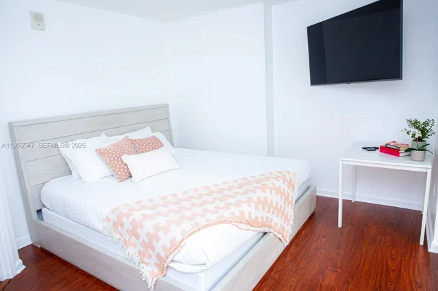 a bedroom with a bed and a flat screen tv