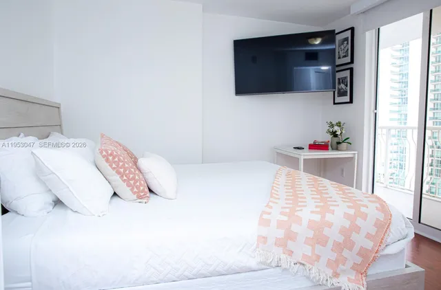 a bedroom with a bed and a flat screen tv