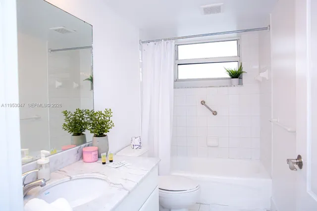 a bathroom with a granite countertop sink a toilet and shower
