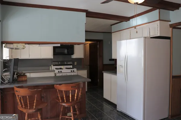 a kitchen with white cabinets and white appliances