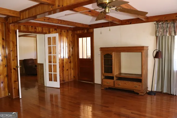 a living room with furniture a flat screen tv and a window