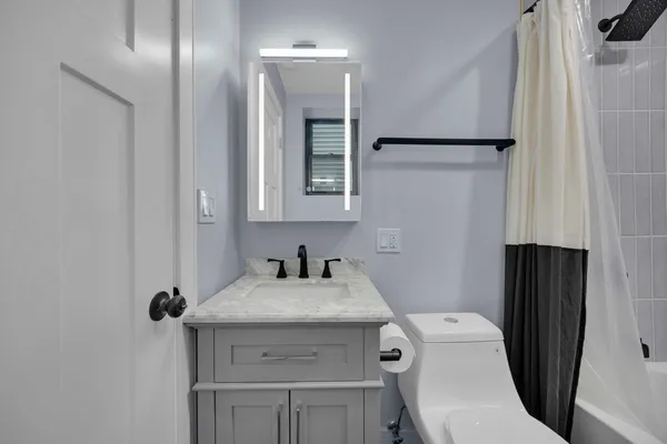 a bathroom with a sink toilet and mirror