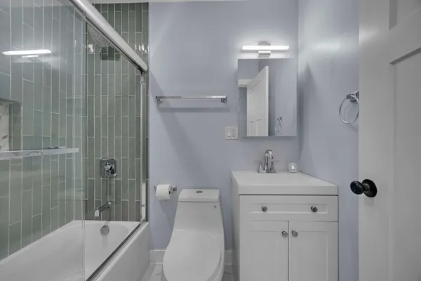 a bathroom with a sink a toilet and shower