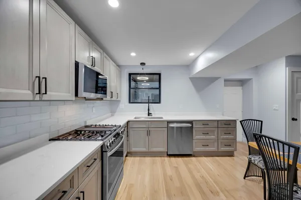 a kitchen with granite countertop a sink cabinets and stainless steel appliances