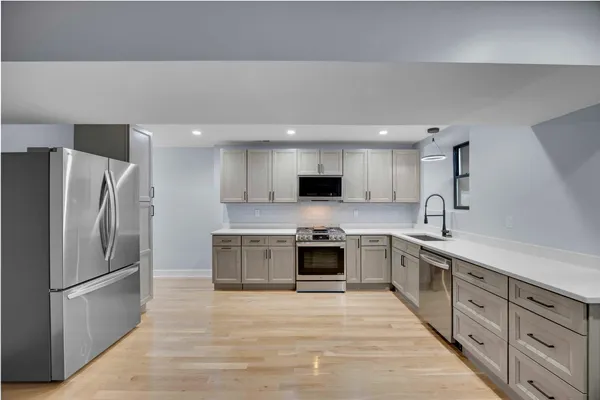 a large kitchen with cabinets stainless steel appliances and a counter space