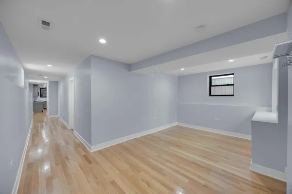 a view of empty room with wooden floor