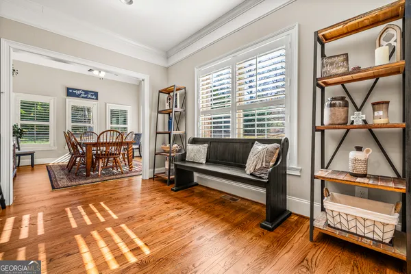 a spacious bedroom with a bed a dresser and a chandelier