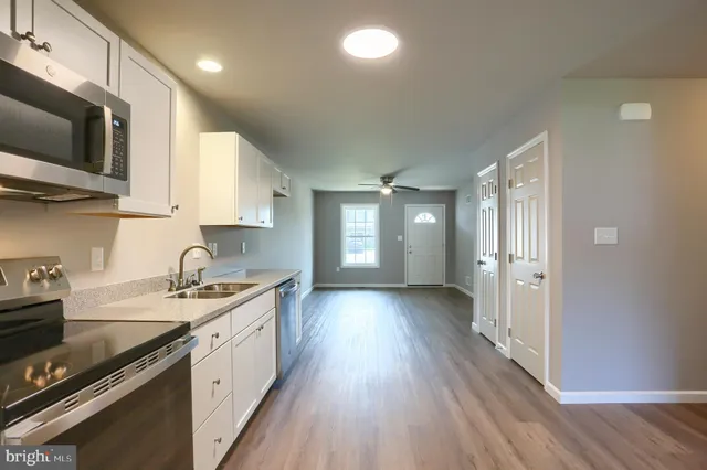 a view of kitchen and hallway with wooden floor