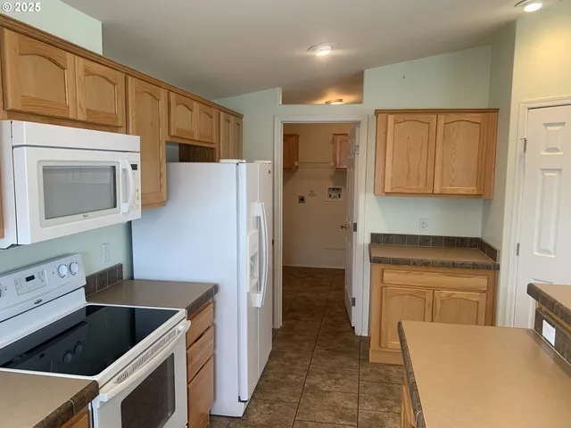 a kitchen with stainless steel appliances granite countertop a refrigerator and a stove top oven