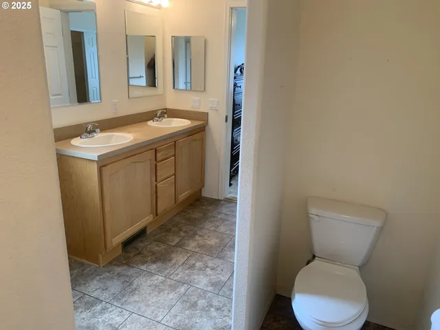 a bathroom with a toilet sink and mirror