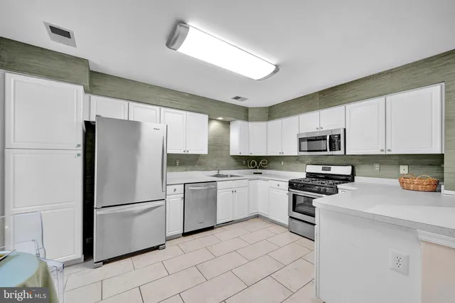 a kitchen with white cabinets and white stainless steel appliances