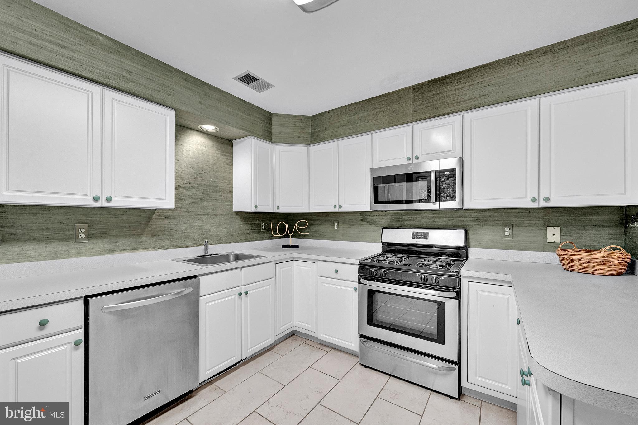 305 Deer Run Court Pennington, NJ 08534 - Photo 17 of 34 a kitchen with white cabinets stainless steel appliances and sink