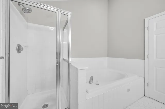 a white bath tub sitting next to a shower