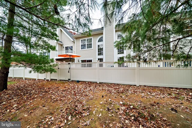 a view of a white house with a large tree