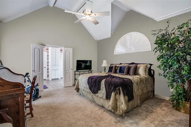 a spacious bedroom with a bed and a chandelier