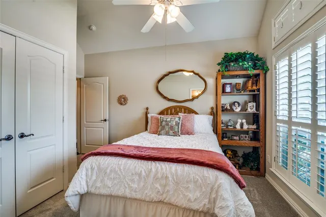 a bedroom with a bed a closet and large window
