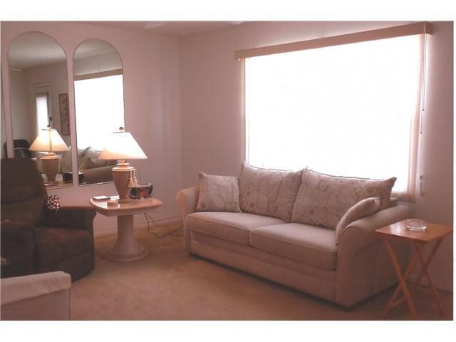 409 Saxony Way, Unit 409 Delray Beach, FL 33446 - Photo 6 of 8 a living room with furniture and a large window